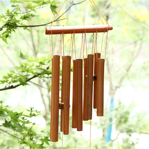 Natural bamboo wind chime with tubes hanging in a peaceful outdoor garden setting
