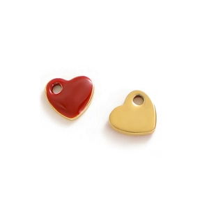 Macro detail of red enamel heart charms and polished gold pendants for DIY jewelry