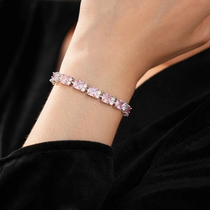 Detalle de pulsera de circonita rosa con piedras plateadas sobre fondo negro