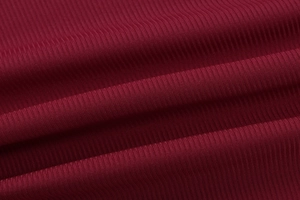 Dettaglio della trama in maglia a coste rosso vino e drappeggio morbido del top