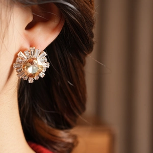 Close-up of vintage sunburst earrings with champagne main stone and radial zircons