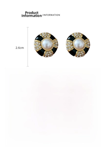 Detail view of retro black and gold round earrings with pearl and crystal accents