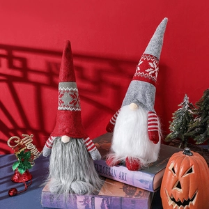 Christmas faceless gnome dolls in red and grey colors set on vintage books as holiday decor