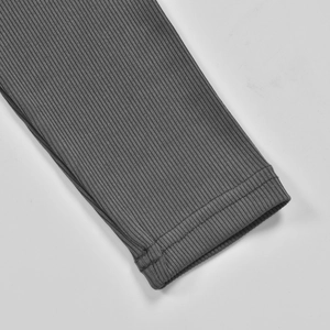 Close-up of dark grey ribbed knit fabric showing detailed texture and sleeve stitching