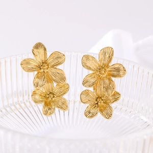Golden double flower stud earrings with metallic luster on elegant textured glass