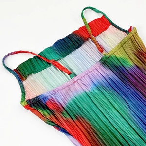 Detail of vibrant rainbow gradient pleats and thin adjustable straps on sun dress