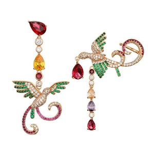 Détail de boucles d'oreilles dorées en forme d'oiseau avec pierres multicolores