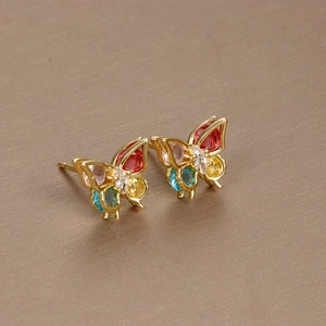 Elegant gold butterfly stud earrings with colorful zircon stones on beige background