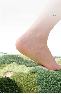 Close-up of thick non-slip bathroom mat showing soft flocking texture under a bare foot