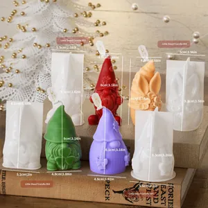 Detalle de cuatro moldes de silicona para velas gnomos con medidas sobre libros antiguos