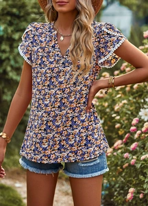 Detail of floral V-neck top showing elegant lace trim on short sleeves in a garden setting