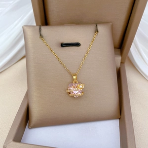 Pink heart crystal necklace with floral accents in a bronze jewelry box on silk