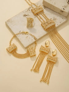 Detailed close-up of gold-plated multi-layer tassel jewelry set with hollowed patterns