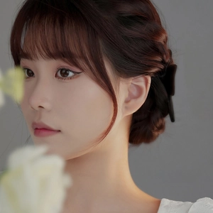 Minimalist S999 sterling silver bow knot stud earrings worn by a model on a clean background