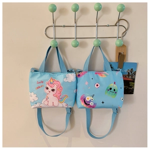 Detail of blue unicorn and Halloween canvas shoulder bags hanging on a white wall hook