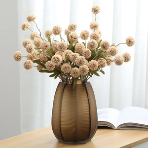 5-head cream dandelion silk flowers in a ribbed brown glass vase on a wooden table