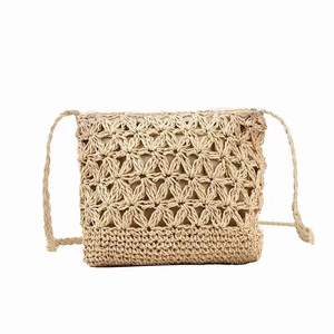 Crossbody woven straw bag with hollow floral pattern and shoulder strap for beach vacation