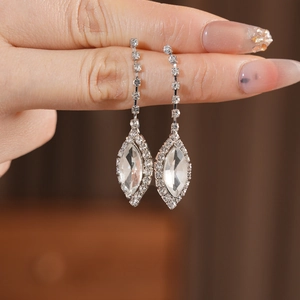 Macro detail of silver dangle earrings with marquise-cut rhinestones and fringe tassels