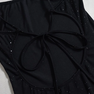 Detail of black ribbed dress featuring shimmering silver glitter and crisscross back ties