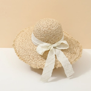 Women's summer straw beach sun hat with large brim and white ribbon for seaside vacations