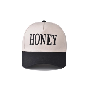 Two-tone cotton baseball cap with cream crown, black brim, and Honey embroidery