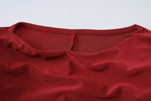 Detail of the crew neckline and double-stitched seams on a dark red bodycon dress