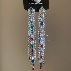 Macro view of colorful crystals and long tassel chains on silver stud earrings