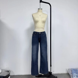 Dettaglio jeans retrò a gamba larga, vita alta, lavaggio baffi ed effetto vintage in blu