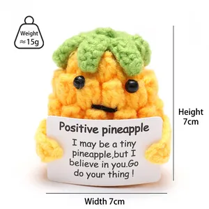 Detail shot of 7cm handmade knitted pineapple doll with encouraging card text