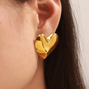 Gros plan d'une puce d'oreille en forme de cœur plaquée or 18 carats au fini poli