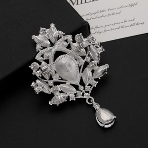 Detail view showing the silver vintage brooch back with pin clasp and teardrop pendant