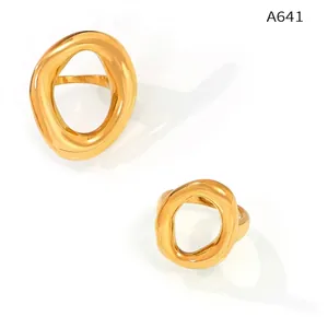 Macro shot of two irregular hollow gold-plated titanium rings with smooth metal texture