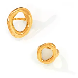 Macro shot of two irregular hollow gold-plated titanium rings with smooth metal texture