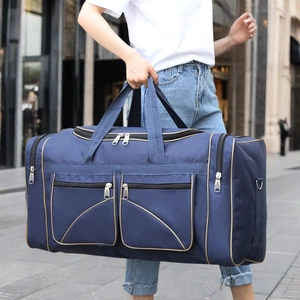Large navy blue canvas travel bag for men with gold zippers shown in urban lifestyle setting