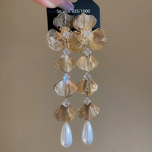 Detail of 18K gold-plated tassel earrings with crystals and white pearl drops