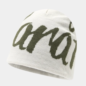 Macro view of cream knit beanie featuring green Chaos script and high density texture