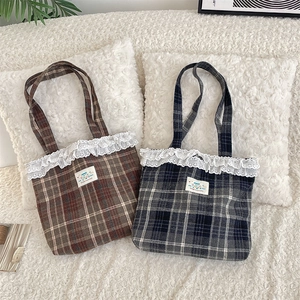 Detailed close-up of vintage plaid tote bags with delicate lace trim and embroidery
