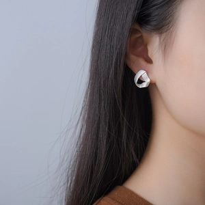 S925 sterling silver twisted triangle hoop earring worn on female model close-up view