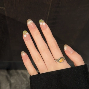 Close-up of translucent cat-eye tulip nails with white floral art and opal ring detail