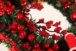 Macro shot of artificial pine needles and shiny red berries for Christmas wreath