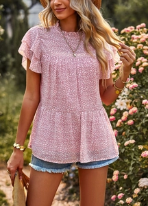Close-up of pink floral top with flutter sleeves and pleated hem in natural light