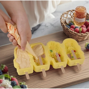Befüllen der vierspaltigen Silikon-Eisform in Blumenform mit Creme und Holzstielen