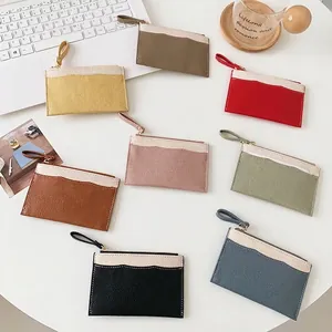 Litchi pattern leather zip wallets with wristlets in 8 colors on an office desk