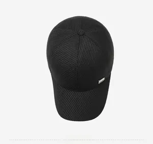 Top view of black baseball cap with fine vertical texture and silver metal tag
