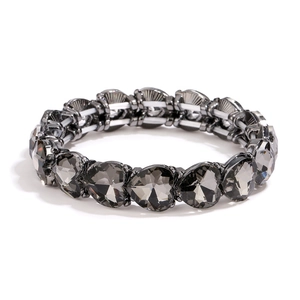 Detail von herzförmigen dunkelgrauen Kristallsteinen auf einem elastischen Metallarmband