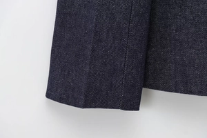 Macro shot of dark blue denim fabric texture with clean stitching and twill weave detail