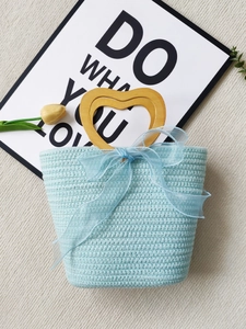Light blue woven tote bag with a heart-shaped wooden handle and ribbon decoration