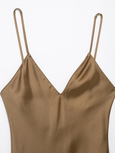 Close-up of the smooth brown satin fabric and delicate V-neckline of the slip dress