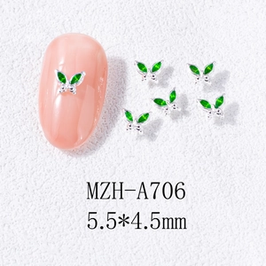 Macro view of 5.5x4.5mm mini green butterfly nail charms with silver metal base