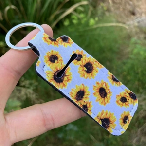 Lipstick holder keychain featuring vibrant sunflower prints with a silver metal ring